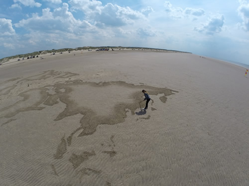 Claire Jamieson making a sand drawing on Southport beach